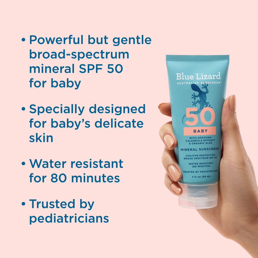 Blue Lizard Baby mineral sunscreen tube held by a hand with product features listed on a pink background